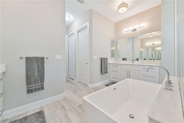 bathroom featuring hardwood / wood-style flooring, vanity, and a bath