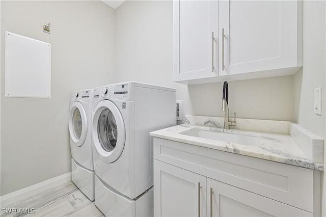 washroom with sink, washer and clothes dryer, and cabinets