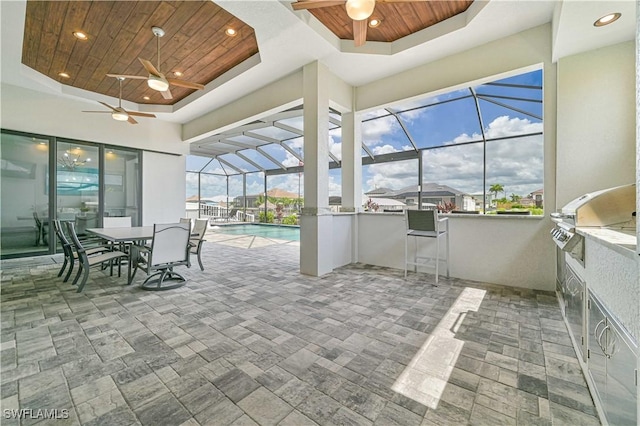 sunroom with a swimming pool, wooden ceiling, ceiling fan, and a tray ceiling