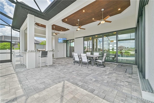 sunroom featuring a skylight, wooden ceiling, and ceiling fan