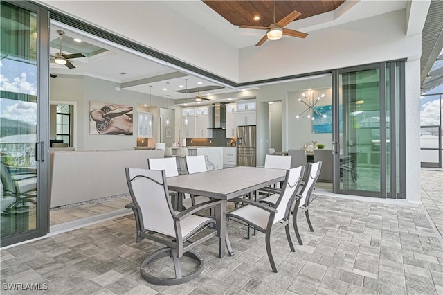 dining space with wood ceiling, a towering ceiling, and ceiling fan with notable chandelier