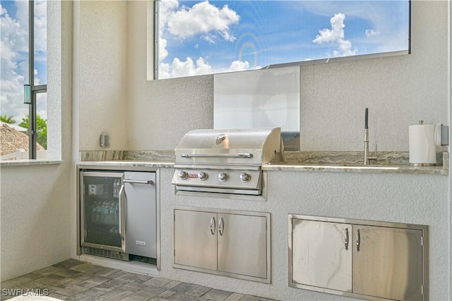 view of patio with area for grilling, a grill, sink, and wine cooler