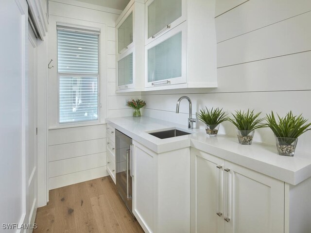 kitchen featuring white cabinetry, light hardwood / wood-style floors, and sink