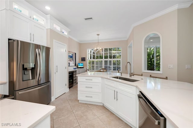 kitchen featuring hanging light fixtures, white cabinets, appliances with stainless steel finishes, and sink