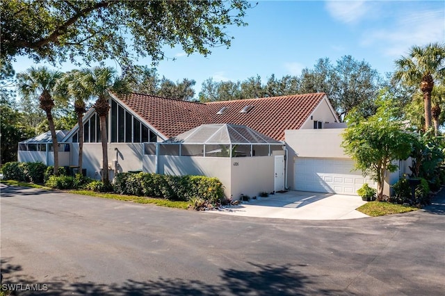 view of front of home featuring a garage and glass enclosure