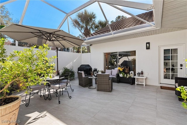 view of patio / terrace with grilling area, outdoor lounge area, and glass enclosure