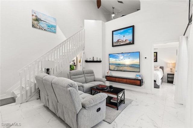 living room featuring ceiling fan and a towering ceiling