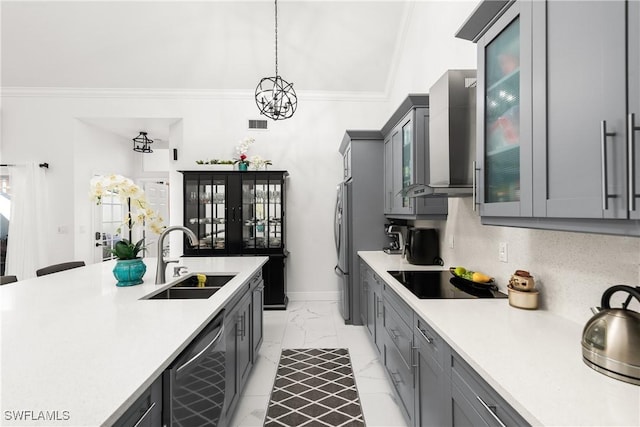 kitchen featuring pendant lighting, sink, wall chimney range hood, stainless steel appliances, and ornamental molding