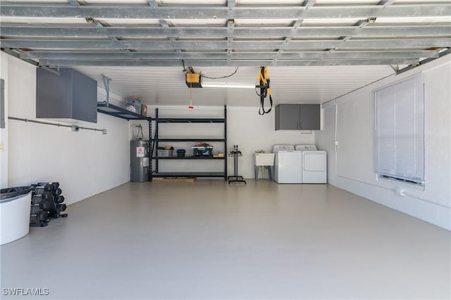 garage featuring water heater, sink, a garage door opener, and washer and clothes dryer