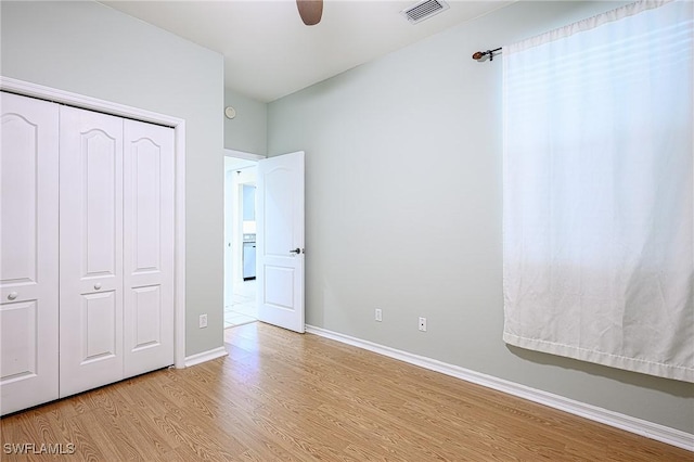 unfurnished bedroom featuring light hardwood / wood-style flooring, a closet, and ceiling fan