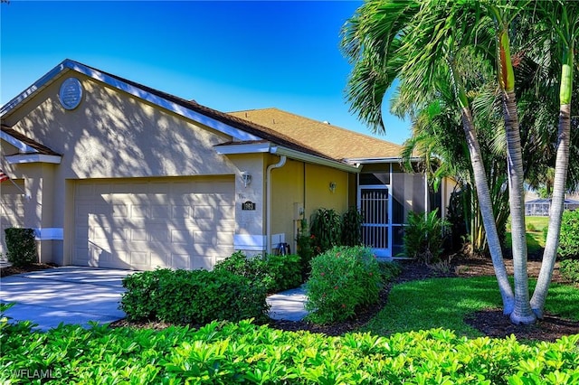 view of front facade with a garage and a sunroom