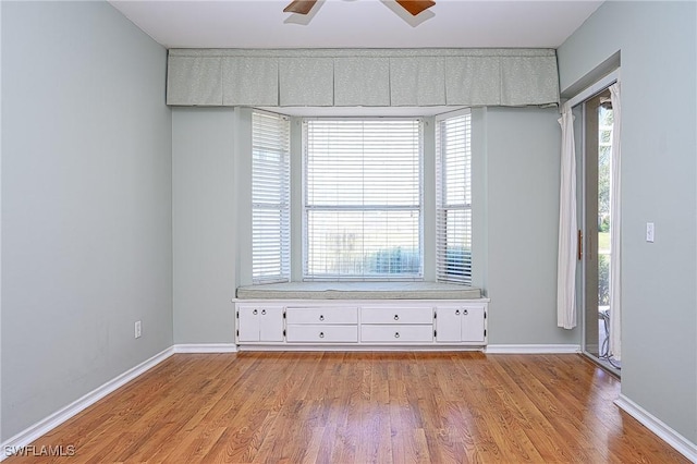 unfurnished room featuring light wood-type flooring, ceiling fan, and a healthy amount of sunlight