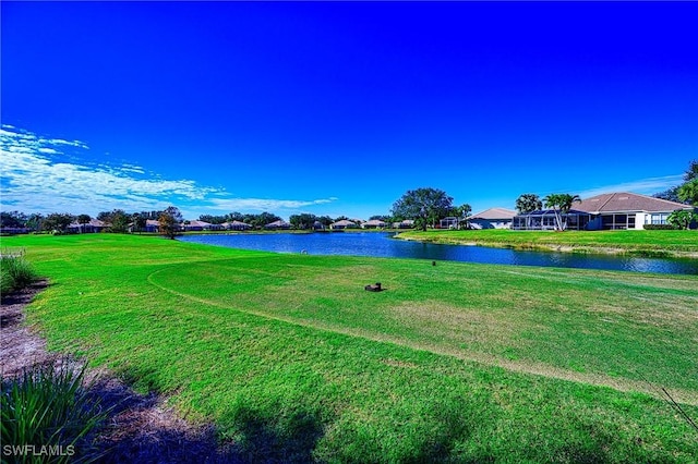 view of home's community with a lawn and a water view