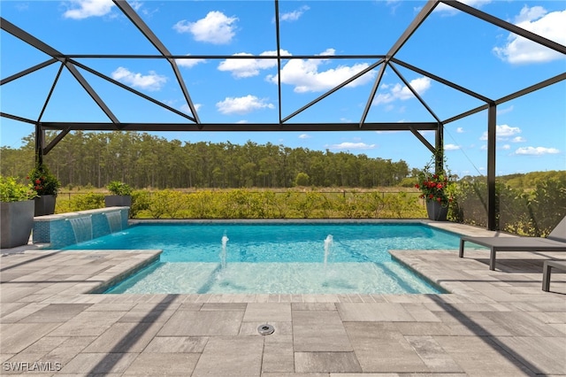 view of swimming pool with pool water feature, a patio area, and a lanai