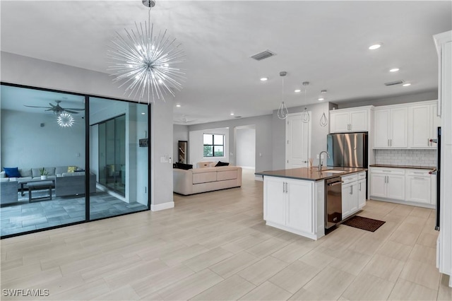 kitchen with white cabinetry, appliances with stainless steel finishes, a kitchen island with sink, and hanging light fixtures