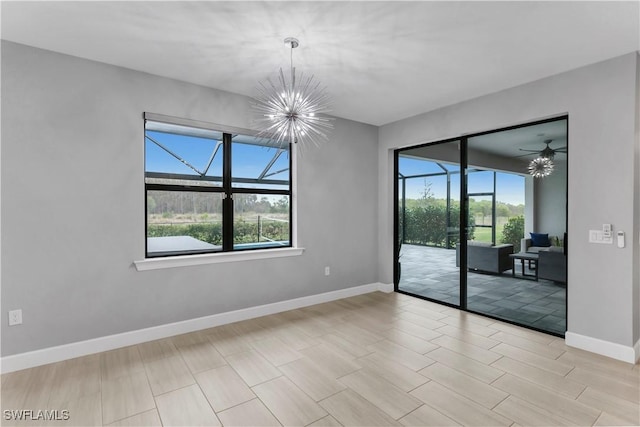 empty room featuring ceiling fan with notable chandelier