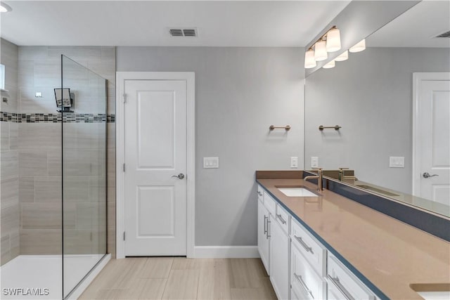 bathroom featuring vanity and tiled shower