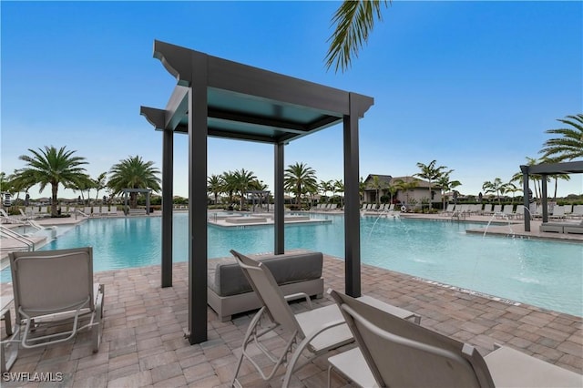 view of pool featuring pool water feature and a patio