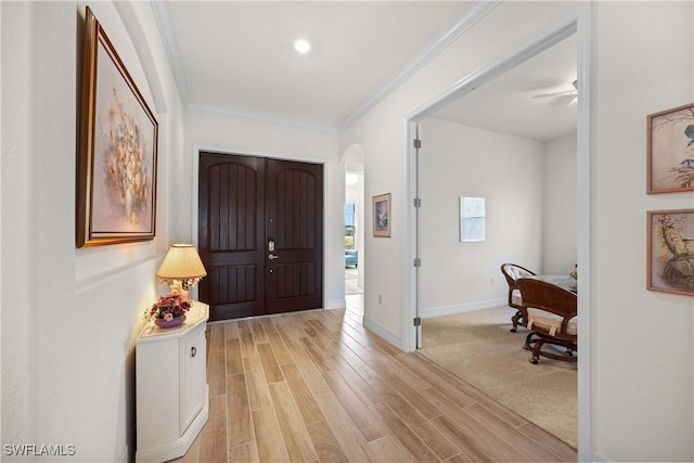 foyer entrance featuring crown molding and light hardwood / wood-style floors