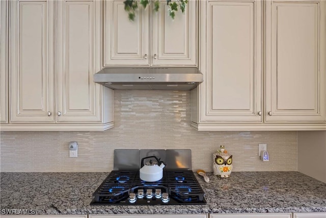 kitchen with white cabinetry, light stone countertops, backsplash, and black gas cooktop