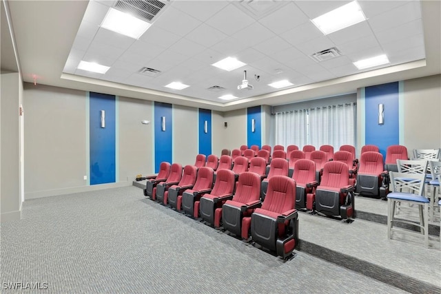 carpeted home theater featuring a tray ceiling and a drop ceiling