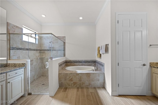 bathroom featuring vanity, ornamental molding, and separate shower and tub