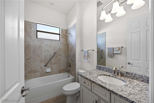 full bathroom featuring vanity, hardwood / wood-style flooring, toilet, and tiled shower / bath