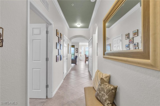 corridor with ornamental molding and light tile patterned floors