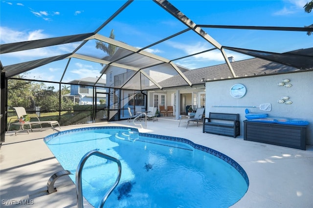 view of pool featuring a hot tub, a patio area, and glass enclosure