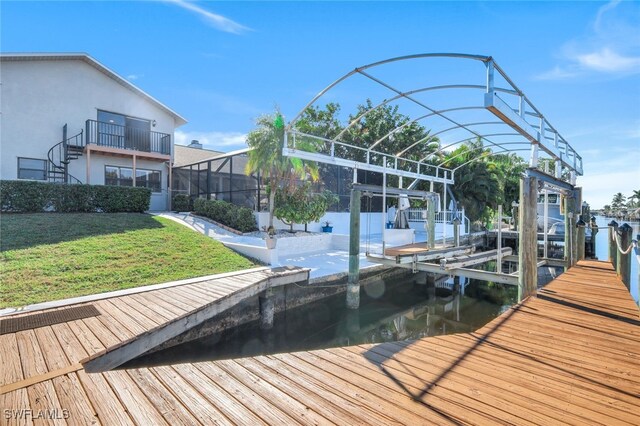 view of dock with a yard and a water view