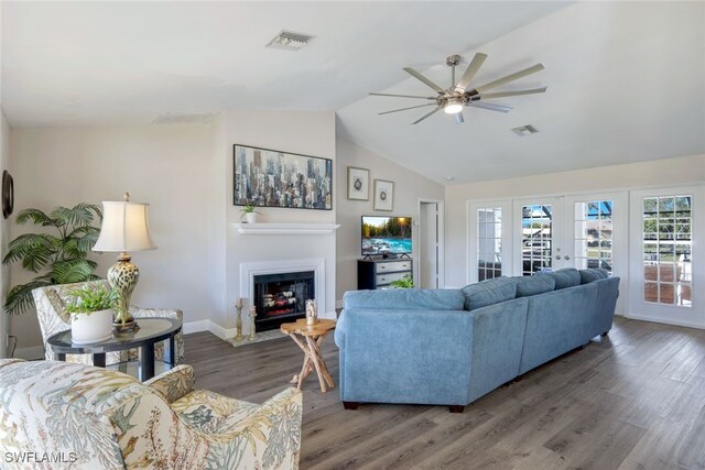 living room with french doors, ceiling fan, lofted ceiling, and dark wood-type flooring