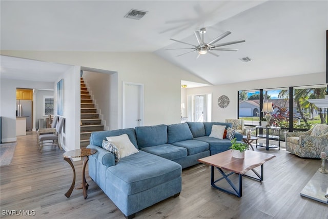 living room with vaulted ceiling, ceiling fan, and light hardwood / wood-style flooring