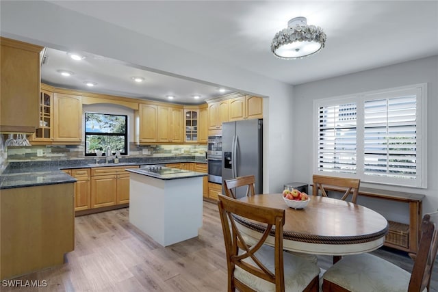 kitchen with stainless steel appliances, a kitchen island, sink, and decorative backsplash