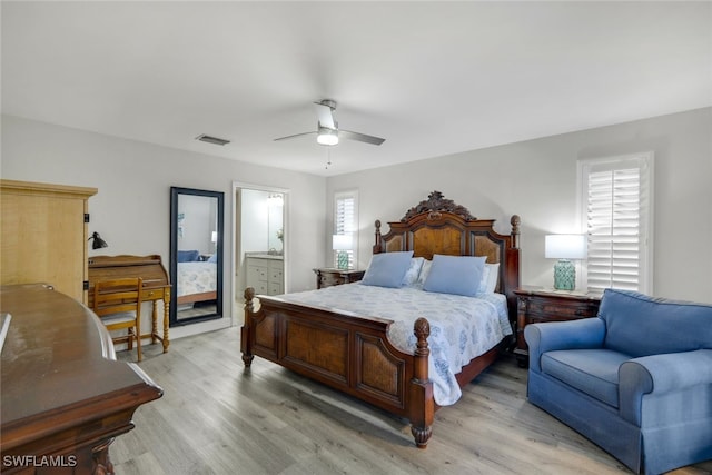 bedroom with light wood-type flooring, ensuite bathroom, and ceiling fan