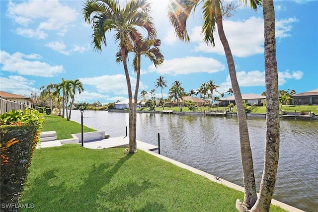 view of dock with a water view and a lawn