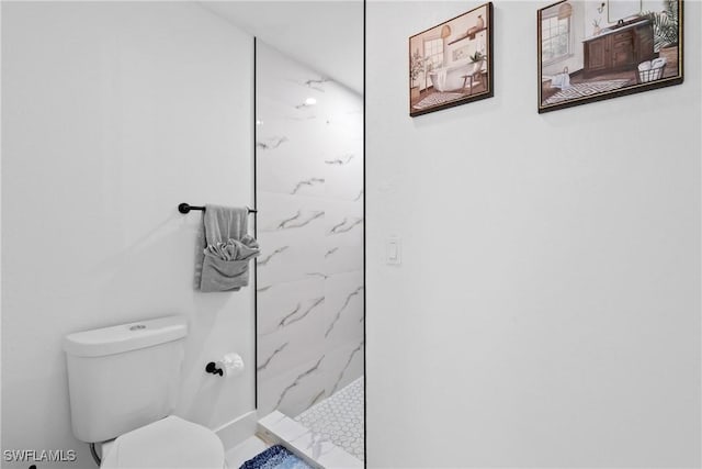 bathroom with toilet and a tile shower