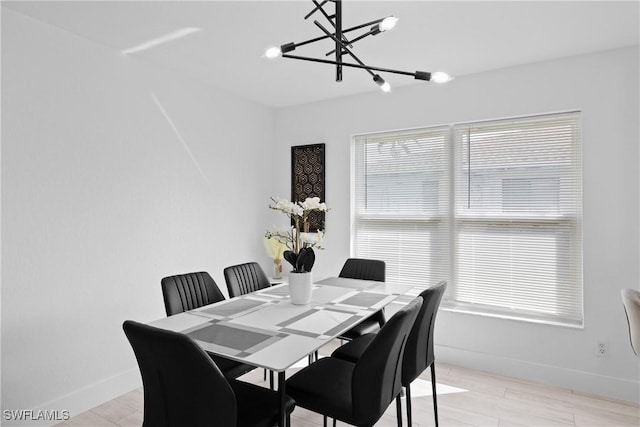 dining area featuring light hardwood / wood-style flooring and a notable chandelier