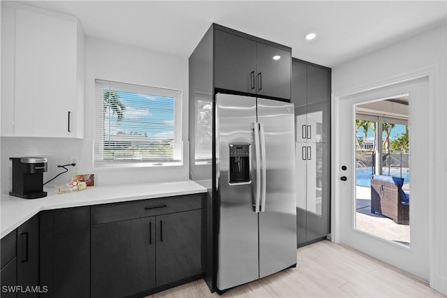 kitchen featuring stainless steel refrigerator with ice dispenser and light hardwood / wood-style floors