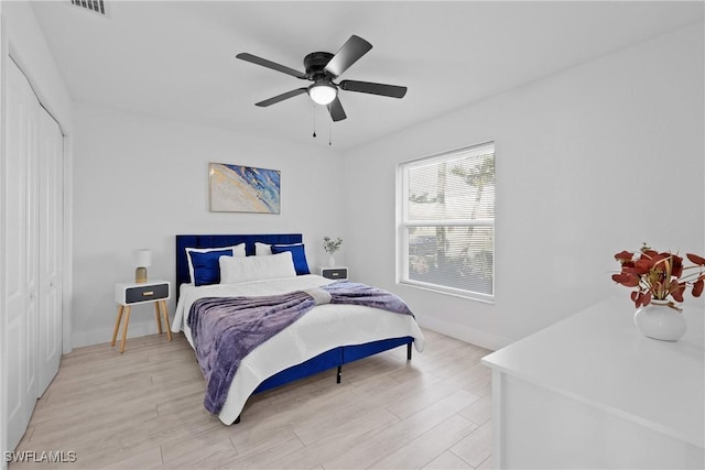 bedroom featuring ceiling fan, light hardwood / wood-style flooring, and a closet