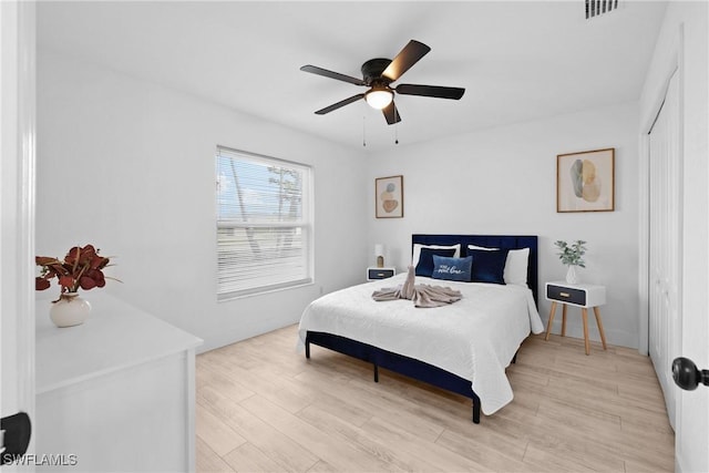 bedroom featuring light wood-type flooring, ceiling fan, and a closet