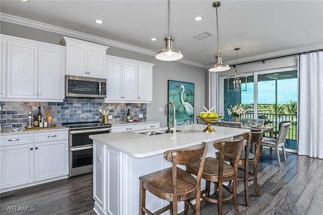 kitchen featuring appliances with stainless steel finishes, white cabinetry, a kitchen island with sink, and sink