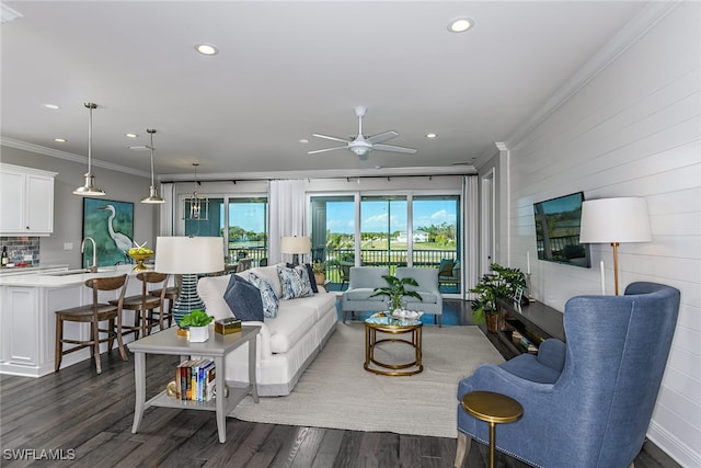 living room featuring ceiling fan, crown molding, dark hardwood / wood-style floors, and sink