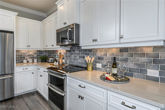 kitchen with white cabinets, appliances with stainless steel finishes, backsplash, and light stone counters