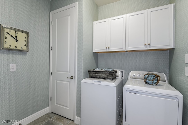 laundry area featuring washing machine and clothes dryer, light tile patterned flooring, and cabinets