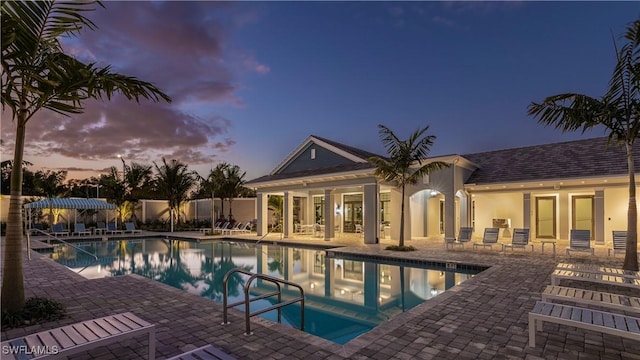 pool at dusk with a patio