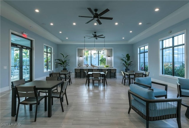 dining space featuring french doors, a tray ceiling, and ceiling fan