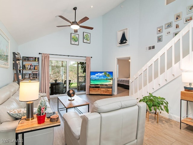 living room featuring high vaulted ceiling, light hardwood / wood-style floors, and ceiling fan