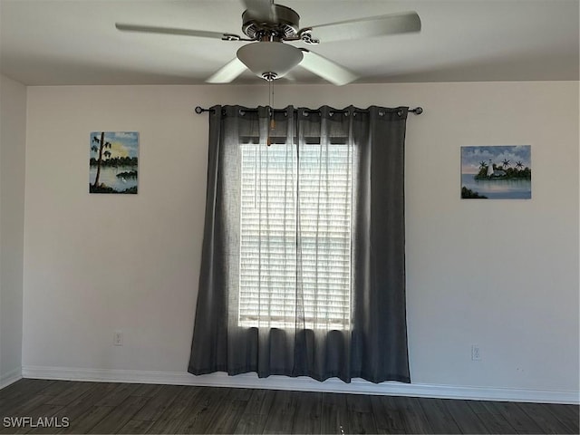 spare room with dark wood-type flooring and ceiling fan