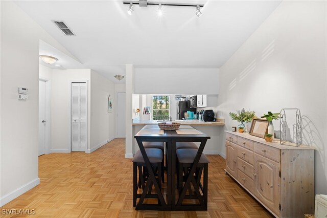 dining room with track lighting, visible vents, and baseboards