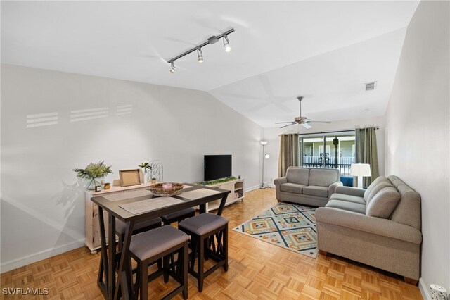 living area with baseboards, visible vents, and vaulted ceiling